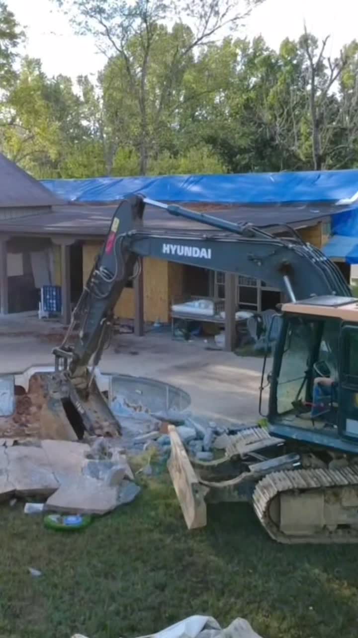 Excavator demolishing a residential pool